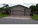 Beige home with a brick driveway and an attached two-car garage at 12126 Homestead Park Ln, Orlando, FL 32824