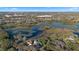 Aerial view shows a home nestled among lush greenery near a lake and surrounding community at 1320 Myrtle Dr, Longwood, FL 32750
