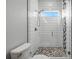 Modern bathroom features a glass-enclosed shower with decorative stone floor and sleek white tile at 1320 Myrtle Dr, Longwood, FL 32750