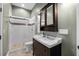 Cozy bathroom with a dark wood vanity, framed mirror, and glass-enclosed shower at 1320 Myrtle Dr, Longwood, FL 32750