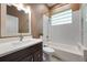Well-lit bathroom featuring a vanity with dark wood cabinets, bathtub, and classic white tiling at 1320 Myrtle Dr, Longwood, FL 32750