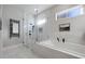 This modern bathroom showcases a glass shower and soaking tub with elegant white marble tile and dark fixtures at 1320 Myrtle Dr, Longwood, FL 32750