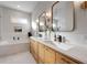 Bright bathroom features double vanity with white countertop, wooden cabinets, and modern gold fixtures at 1320 Myrtle Dr, Longwood, FL 32750