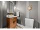 Bathroom with warm wood vanity, brass accents, and mosaic tile flooring creating a cozy and stylish space at 1320 Myrtle Dr, Longwood, FL 32750