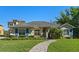 Beautiful front exterior of a single-story home with a winding brick walkway and lush landscaping at 1320 Myrtle Dr, Longwood, FL 32750