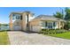 Stately home features an interlock driveway, three-car garage, and beautifully landscaped front yard near a lake at 1320 Myrtle Dr, Longwood, FL 32750