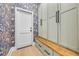 The mudroom features stylish wallpaper, storage cabinets, a wooden bench, and a convenient door to the exterior at 1320 Myrtle Dr, Longwood, FL 32750