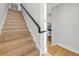 Light wood staircase featuring white risers, handrail and walls, with a glimpse of the kitchen at 1320 Myrtle Dr, Longwood, FL 32750