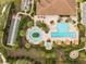 Overhead view of clubhouse featuring a pool, spa, bocce court, and lounge areas surrounded by lush tropical landscaping at 1392 Zeek Ridge St, Clermont, FL 34715