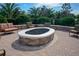 Outdoor fire pit with brick surround and cushioned seating area in landscaped yard at 1392 Zeek Ridge St, Clermont, FL 34715