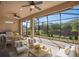 Relaxing screened patio featuring a full outdoor kitchen, dining table and comfortable lounge area with a view of the beautiful landscaping at 1392 Zeek Ridge St, Clermont, FL 34715