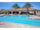 A refreshing community pool offering lounge seating, palm trees, tiled borders, and a convenient chair lift at 1392 Zeek Ridge St, Clermont, FL 34715