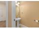 A simple powder room with a pedestal sink, bright lighting, and tile floors at 1392 Zeek Ridge St, Clermont, FL 34715