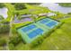 An aerial view of the community tennis courts and a pool with surrounding greenery at 1401 Royal Saint George Dr, Orlando, FL 32828