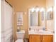 Bathroom with well-lit mirror, white shower curtain, and wood cabinetry at 1401 Royal Saint George Dr, Orlando, FL 32828