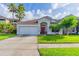 Charming single-story home with a well-manicured lawn and a red front door at 1401 Royal Saint George Dr, Orlando, FL 32828