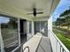 The condo balcony features a ceiling fan, white railings, sliding glass doors, and a glimpse of the beautiful view at 14025 Fairway Island Dr # S, Orlando, FL 32837