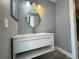 Bathroom featuring modern white vanity with open storage and large circular mirror at 14025 Fairway Island Dr # S, Orlando, FL 32837