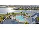 Aerial view of community pool area with lounge chairs, palm trees and a lake with neighborhood houses in the background at 14146 Lanikai Beach Dr, Orlando, FL 32827