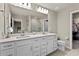 Spacious double vanity bathroom with large mirrors, all white features, and walk-in shower at 14146 Lanikai Beach Dr, Orlando, FL 32827