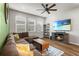Cozy living room with a comfortable brown sectional couch, modern TV console with fireplace, and bright natural light at 14146 Lanikai Beach Dr, Orlando, FL 32827
