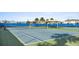 Community tennis court featuring blue floor, green borders, black fencing and a covered seating area at 14146 Lanikai Beach Dr, Orlando, FL 32827