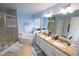 Well-lit bathroom featuring a large double sink vanity with granite countertops and a separate shower at 14415 Estrella Dr, Orlando, FL 32837