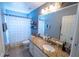 Bright bathroom featuring granite countertops, white cabinets, and a shower with curtain at 14415 Estrella Dr, Orlando, FL 32837