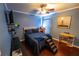 Comfortable blue bedroom features a ceiling fan, hardwood floors and cute dog steps at 14415 Estrella Dr, Orlando, FL 32837