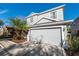 Gray two-story home boasts a lush, tropical landscaped yard and a spacious two-car garage at 14415 Estrella Dr, Orlando, FL 32837