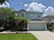 Charming two-story home with a gray exterior, a well-manicured lawn, and a two-car garage at 14415 Estrella Dr, Orlando, FL 32837