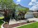 Inviting two-story home featuring a manicured front yard with mulch landscaping, walkway and a two-car garage at 14415 Estrella Dr, Orlando, FL 32837