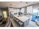 Open kitchen with white cabinetry, marble flooring, stainless steel appliances, and a large gray island with seating at 14415 Estrella Dr, Orlando, FL 32837