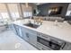 Kitchen island with gray cabinets, marble countertop, stainless steel sink, and stainless steel appliances in the background at 14415 Estrella Dr, Orlando, FL 32837