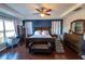 Stylish main bedroom featuring tray ceilings, dark wood furniture and hardwood floors at 14415 Estrella Dr, Orlando, FL 32837