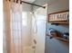Shower detail with a white shower curtain, tiled walls, and charming shelf decor at 14415 Estrella Dr, Orlando, FL 32837