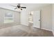 Spacious carpeted main bedroom features a ceiling fan and a sunny window at 16060 Sw 21St Terrace Rd, Ocala, FL 34473