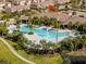 Aerial view of the community pool with surrounding palm trees and lounge chairs, near the indicated home at 16133 Pebble Bluff Loop, Winter Garden, FL 34787