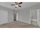 Neutral bedroom features a ceiling fan, carpeted floors, and doors to the bathroom and closet at 193 Longview Ave # 104, Kissimmee, FL 34747