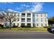 Three-story building with multiple balconies, showcasing architectural details and an adjacent parking area at 193 Longview Ave # 104, Kissimmee, FL 34747