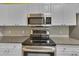 Updated kitchen features white cabinets, granite counters, stainless steel appliances, and modern backsplash at 193 Longview Ave # 104, Kissimmee, FL 34747