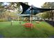 Community playground with picnic tables, swings and slides, and a shade structure, surrounded by artificial turf at 193 Longview Ave # 104, Kissimmee, FL 34747