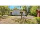 Back of the house with a small deck and a spacious, private backyard surrounded by mature trees at 20660 Se 155Th St, Umatilla, FL 32784