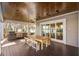 An outdoor covered patio with a barbecue, dining table, and views of the lake through sliding glass doors at 2118 Lake Dr, Winter Park, FL 32789
