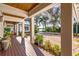 Inviting covered porch with wood floors, landscaping, and views of the property at 2118 Lake Dr, Winter Park, FL 32789