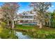 Stunning lakefront home featuring a pool, covered patio, and lush landscaping at 2118 Lake Dr, Winter Park, FL 32789