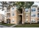 Exterior view of a tan apartment building with two palm trees and stairs to the units at 2304 Silver Palm Dr # 103, Kissimmee, FL 34747