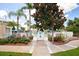 Pool area entrance with lush landscaping, a gated fence, and palm trees at 2304 Silver Palm Dr # 103, Kissimmee, FL 34747