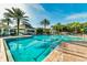 Resort-style pool area with lounge chairs and palm trees under a bright sky at 2304 Silver Palm Dr # 103, Kissimmee, FL 34747