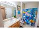 Bright bathroom features a single sink vanity, toilet, and shower with a themed shower curtain at 2412 Caravelle Cir, Kissimmee, FL 34746